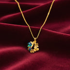 Gold necklace with a green gemstone on a white background